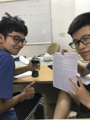 Two students with a physics worksheet in a Hanoi classroom