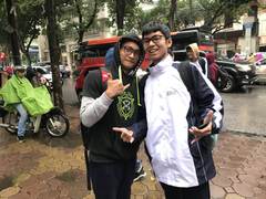 Friends in school jackets on a rainy Hanoi street