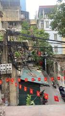 An alley with Vietnamese flags and overhead wires