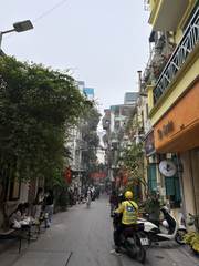 A narrow Hanoi street lined with cafés and motorbikes