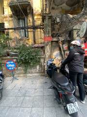 A scooter parked beside old buildings and overhead wires