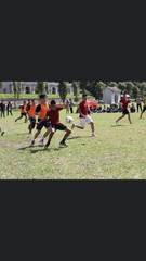 Students playing football on a grass field