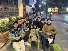 A group of friends drinking tea on the sidewalk at night
