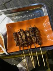 Grilled skewers on an orange plate