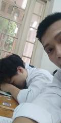 A classroom selfie beside a friend sleeping at a desk