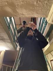 Two friends photographing their reflection in a stairwell