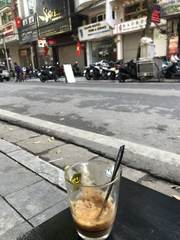 A glass of coffee beside a Hanoi street
