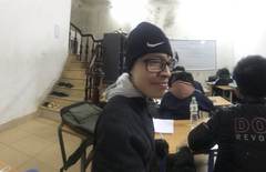 A student wearing a beanie at a classroom desk