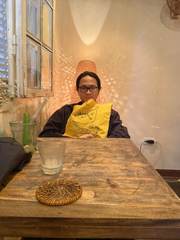 A friend holding a yellow cushion in a café
